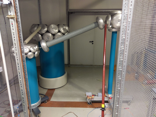 Prüfaufbau im Hochspannungslabor mit 200 kV Prüftransformator und Spannungsteiler Prüfaufbau im Hochspannungslabor mit 200 kV Prüftransformator und Spannungsteiler
